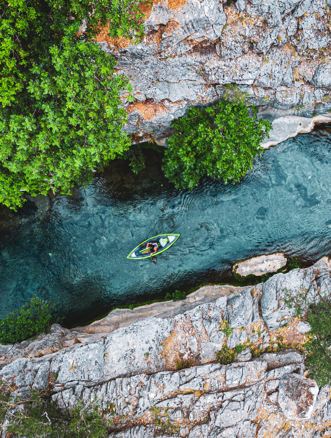 Aerial view of Kayak on river flowing in canyon