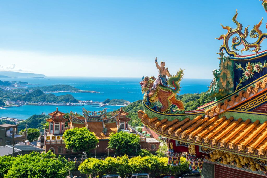Taipei, Taiwan - Sicht vom Berg auf das grüne, bergige Tal mit viel Meer im Hintergrund, Sonne scheint