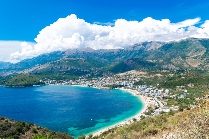 Panoramablick von oben auf den Ferienort Himarë. Wunderschöne sommerliche Berglandschaft mit Wolken. Ionisches Meer. Albanien.