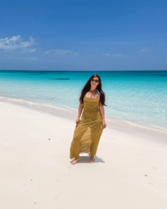 Frau steht in Kleid am Strand