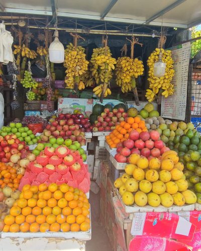 Obststand auf einem Markt in Sri Lanka mit Bananen, Mangos, Granatäpfeln und weiteren tropischen Früchten.