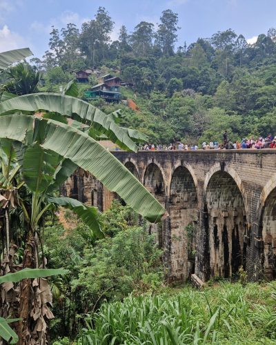 Nine Arches Bridge bei Ella in Sri Lanka, umgeben von tropischer Vegetation und bewaldeten Hügeln.