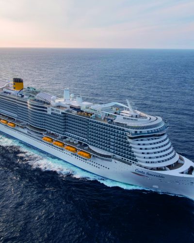 Luftaufnahme der Costa Smeralda von Costa Kreuzfahrten auf dem offenen Meer mit sichtbaren Decks und Sonneneinstrahlung.